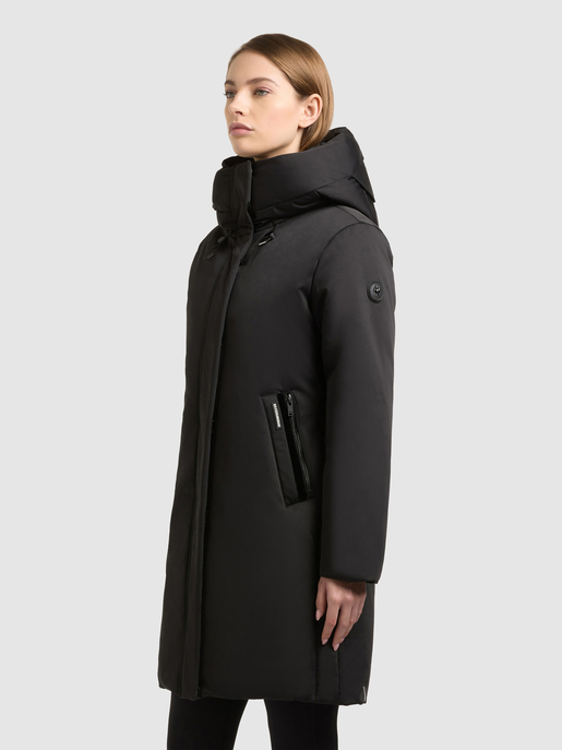 Model trägt schwarzen, knielangen Wintermantel mit hohem Kragen und Reißverschlusstasche.