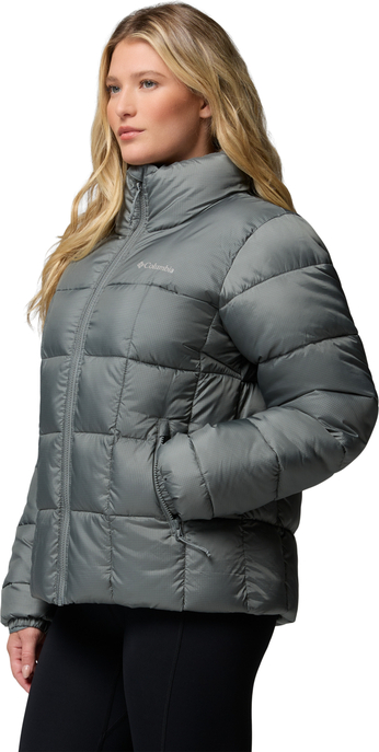 Graue Columbia-Steppjacke mit hohem Kragen, Reißverschluss und seitlichen Taschen, am Model getragen.
