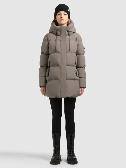 Model trägt graubraunen Steppmantel mit hohem Kragen und schwarzer Strickmütze.