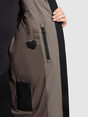 Detailansicht des Innenfutters einer braunen Jacke mit Reißverschlusstasche und Etikett.