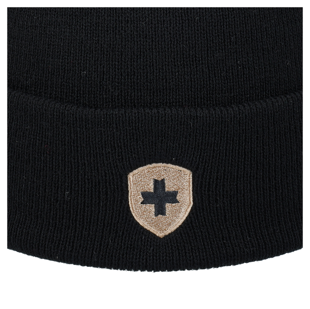Detailansicht einer schwarzen Strickmütze mit beigem Wappenaufnäher und schwarzem Kreuz.
