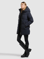 Model trägt einen dunkelblauen, gesteppten Parka mit Kapuze und Stehkragen.