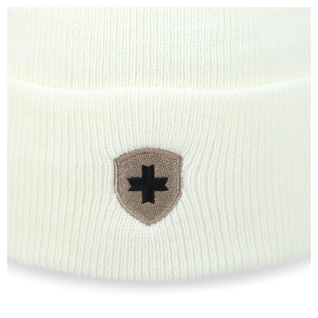 Detailansicht einer cremeweißen Strickmütze mit aufgesticktem Wappen und schwarzem Kreuz