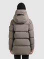 Rückenansicht einer taupefarbenen Steppjacke mit Kapuze, getragen von einem Model mit schwarzer Strickmütze.