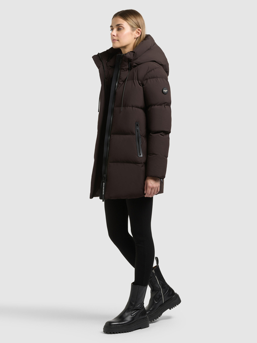 Model trägt dunkelbraunen, wattierten Parka mit Kapuze und Reißverschlusstaschen.